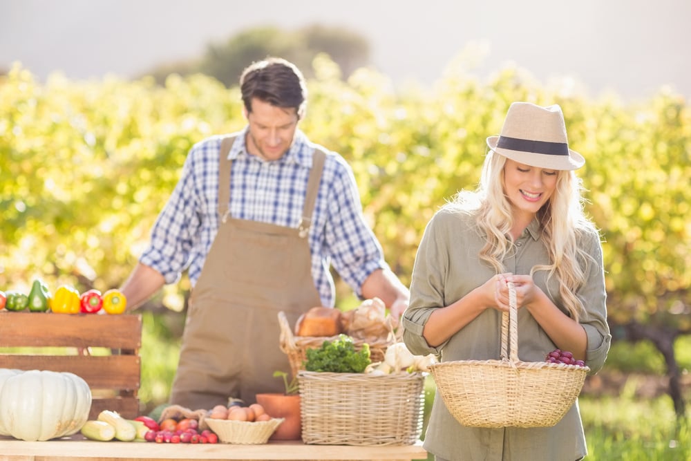 Blonde customer holding a vegetables basket at the local market